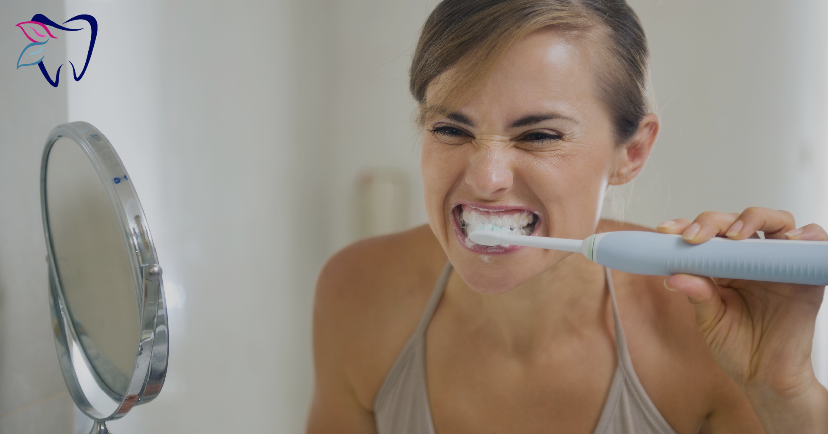 Woman brushing her teeth near a mirror