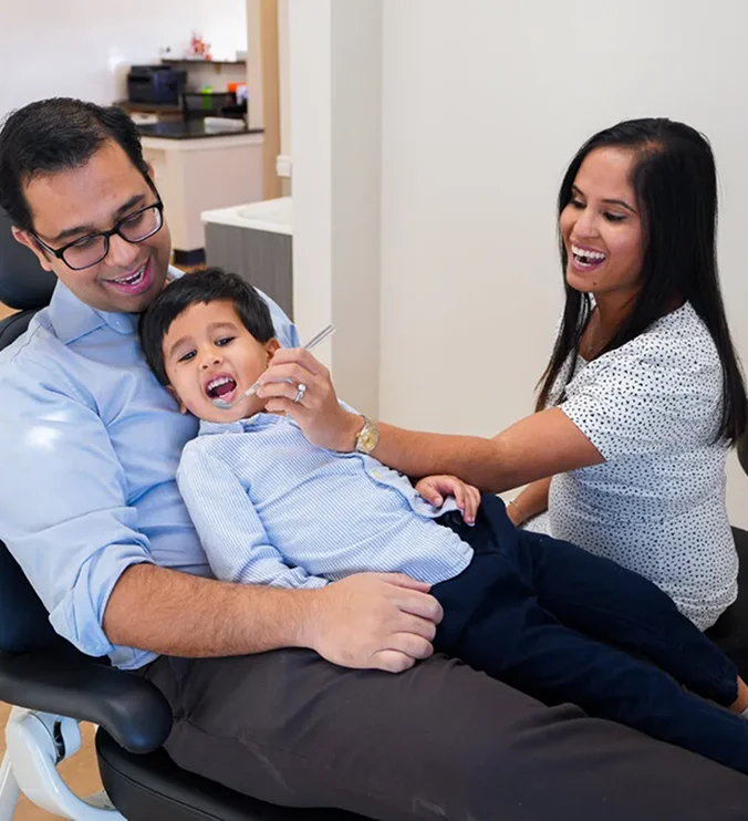 Dentist welcoming a young patient and family at Petal Dental