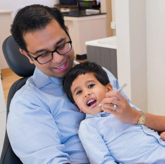 Man and young boy smiling in a dental chair