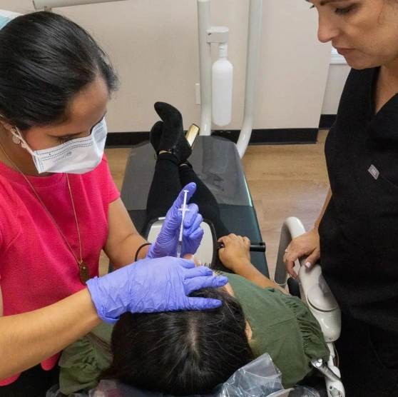 Two dental professionals treating a patient