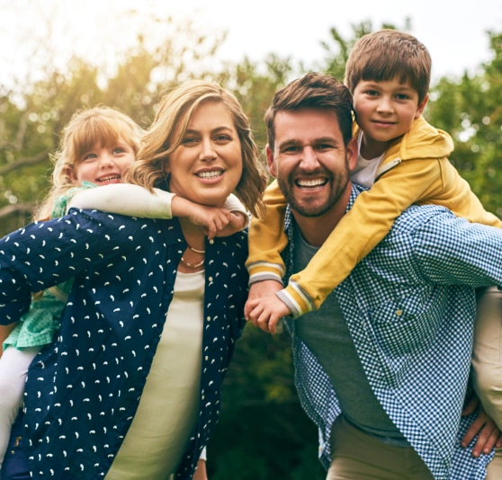 Family with young children smiling outdoors